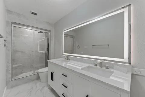 a bathroom with double sink and a mirror