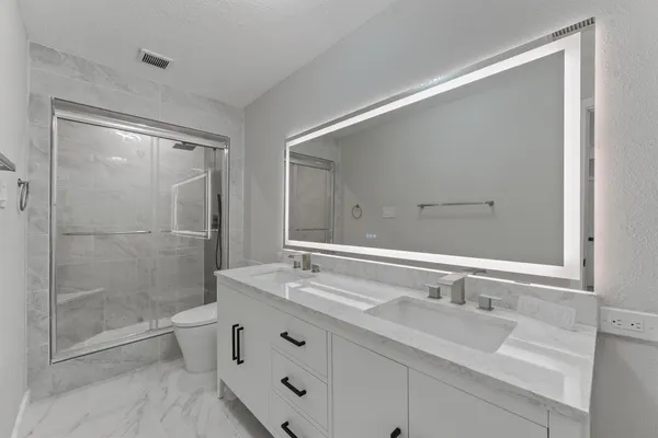 a bathroom with double sink and a mirror
