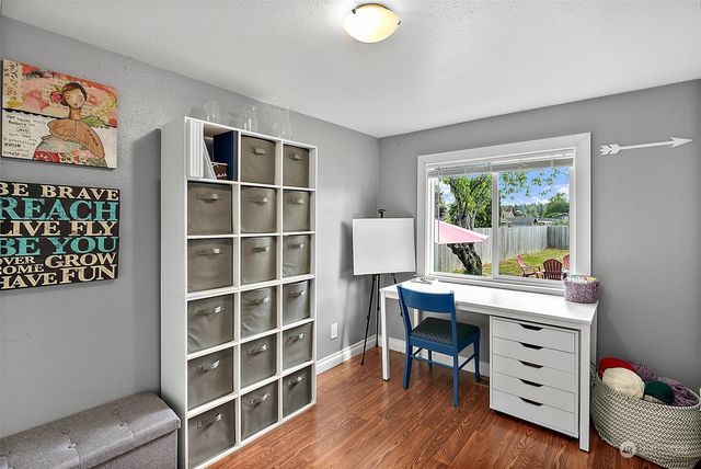 a view of a workspace with furniture and a window