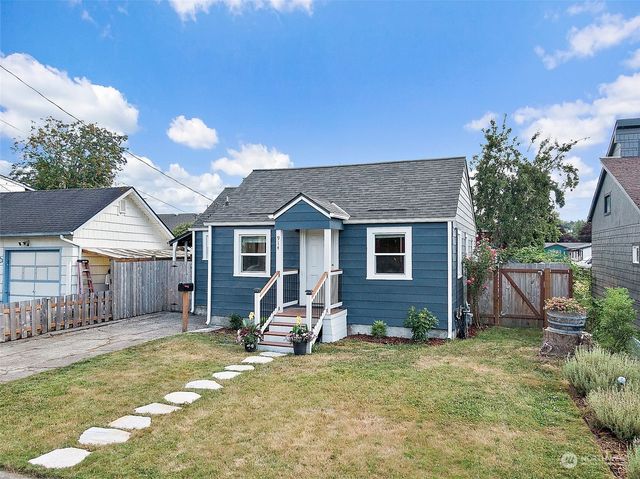 a view of a house with a yard and wooden fence