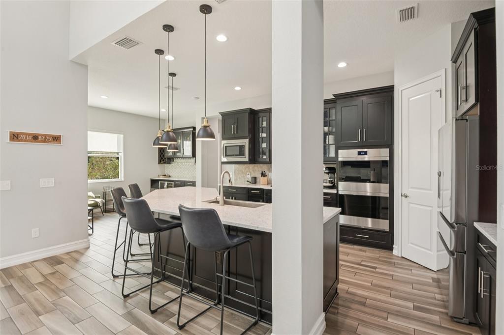 1440 Keystone Ridge Circle Tarpon Springs, FL 34688 - Photo 13 of 45 a kitchen with stainless steel appliances kitchen island granite countertop a refrigerator and a stove top oven