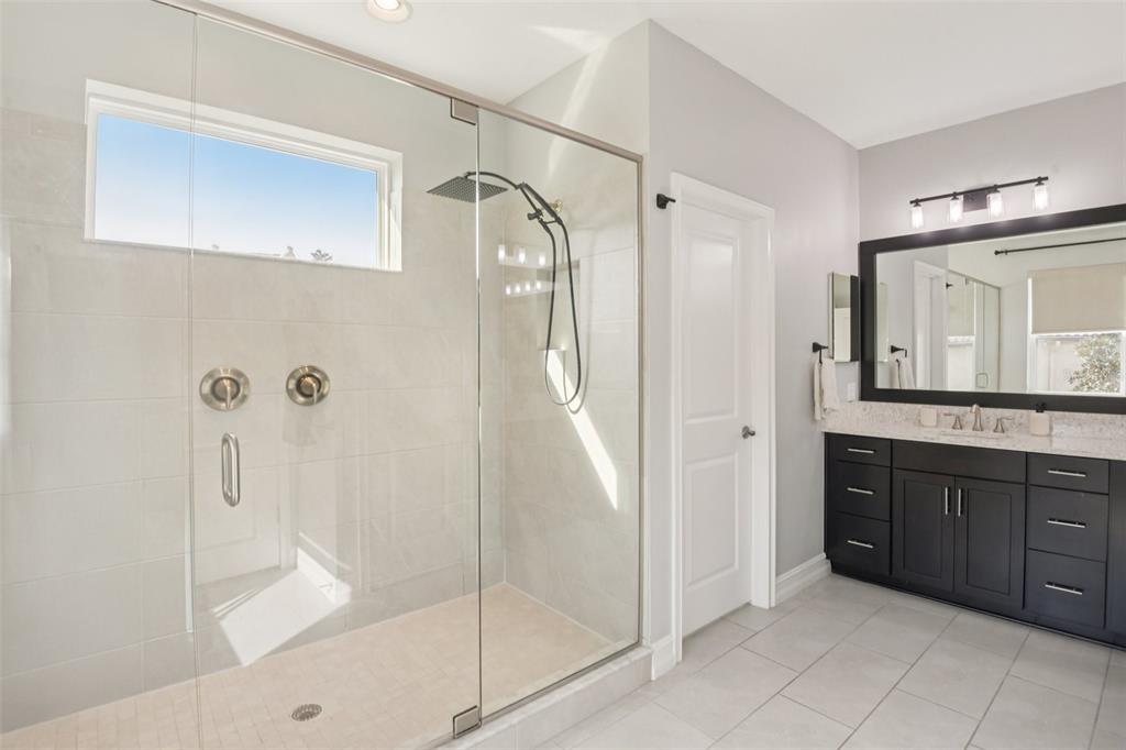 1440 Keystone Ridge Circle Tarpon Springs, FL 34688 - Photo 20 of 45 a bathroom with a glass door shower a sink and a mirror