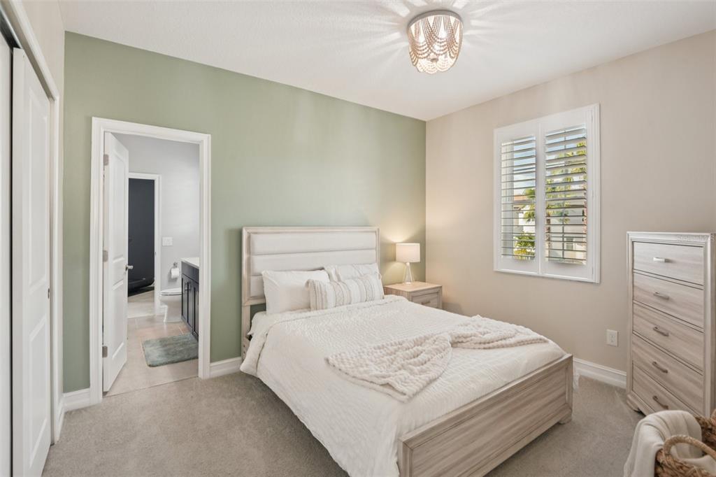 1440 Keystone Ridge Circle Tarpon Springs, FL 34688 - Photo 25 of 45 a bedroom with a bed and a chandelier