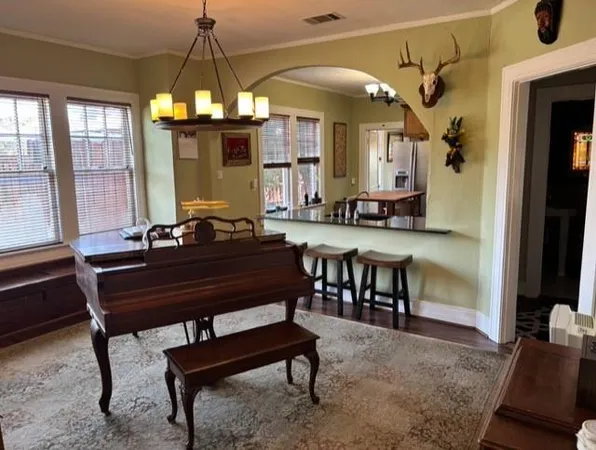 a room with a table chairs and a chandelier