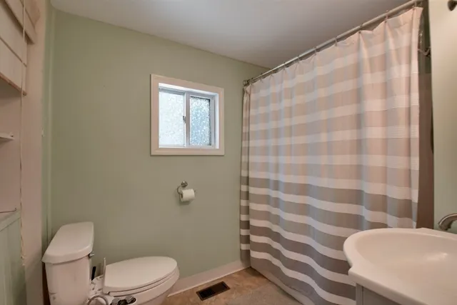 a white toilet sitting next to a shower curtain