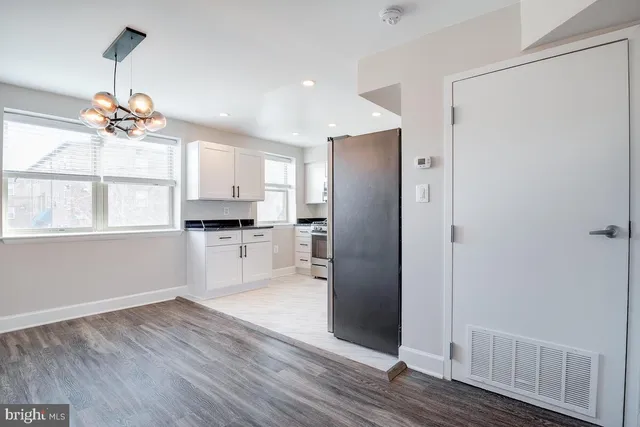 a kitchen with stainless steel appliances a refrigerator and wooden floor