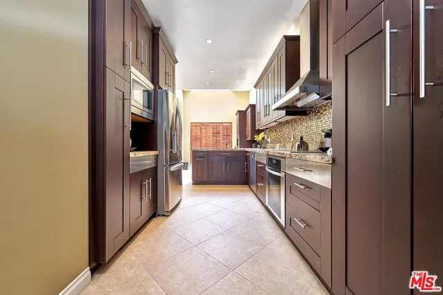 a kitchen with stainless steel appliances granite countertop a sink refrigerator and cabinets
