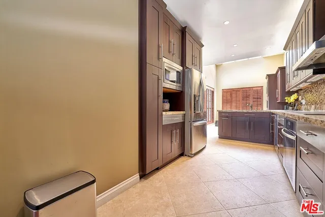 a kitchen with stainless steel appliances kitchen island granite countertop a table chairs in it and wooden floors