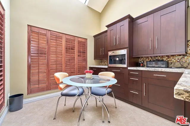 a bathroom with a granite countertop sink a toilet a mirror and shower