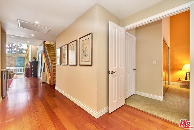 a view of a hallway with wooden floor windows and a living room