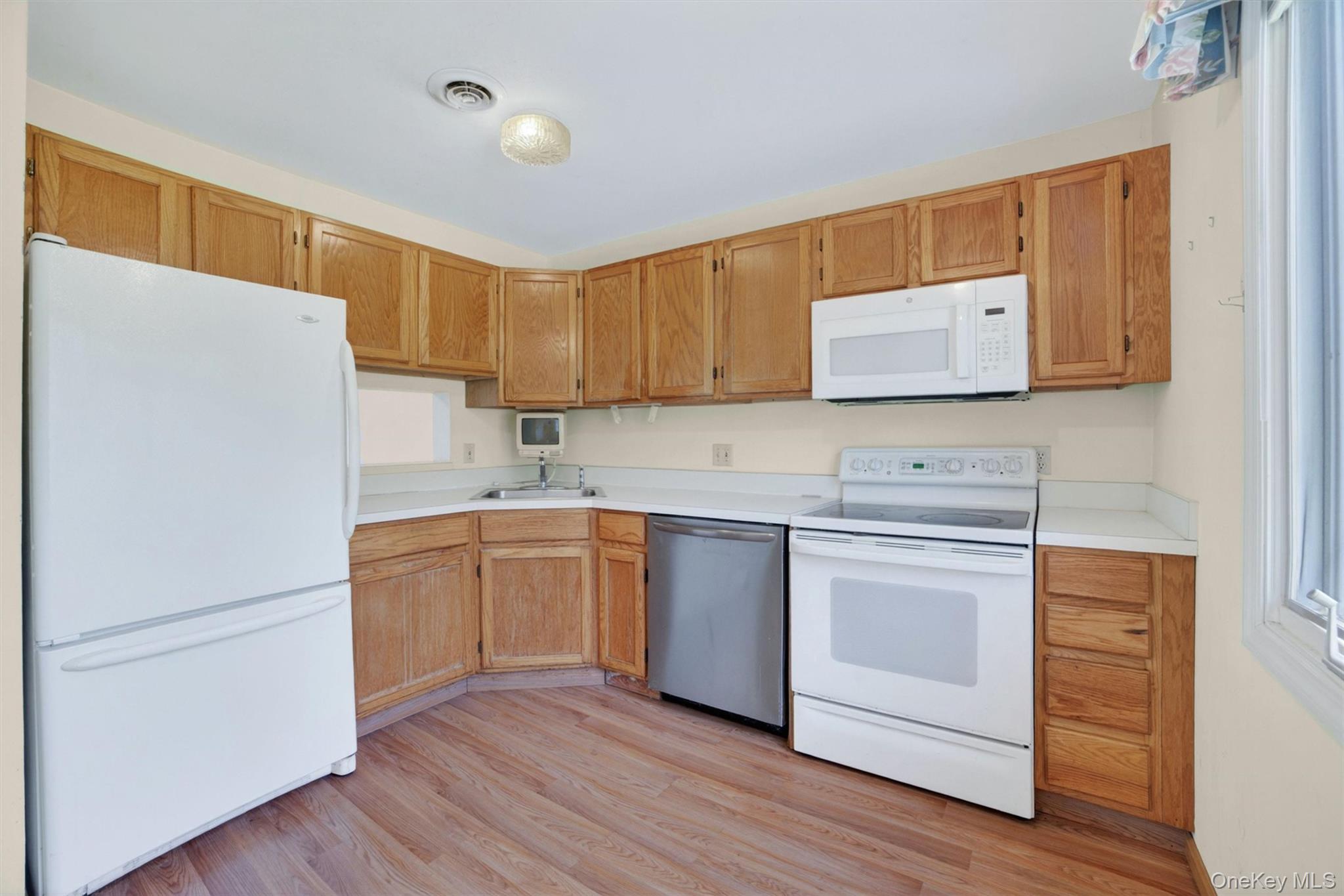 116 Fields Lane Peekskill, NY 10566 - Photo 6 of 40 a kitchen with stainless steel appliances white cabinets and a refrigerator