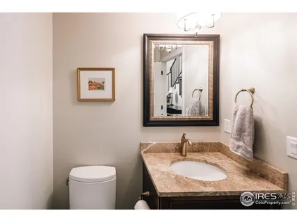 a bathroom with a granite countertop sink a mirror and a toilet