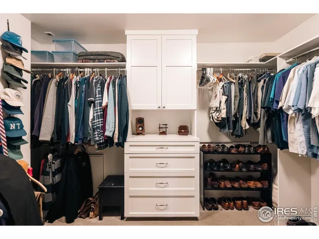 a view of walk in closet with clothes and shoes