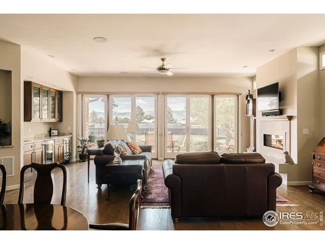a living room with furniture large windows and flat screen tv
