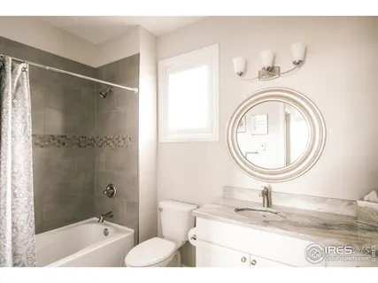 a bathroom with a granite countertop sink toilet and a mirror