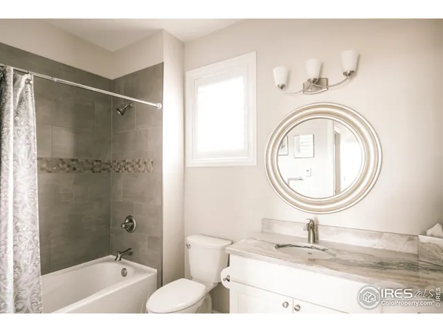 a bathroom with a granite countertop sink toilet and a mirror