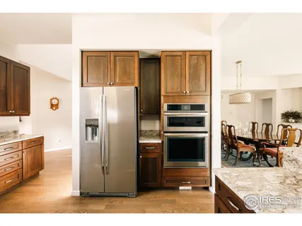a kitchen with stainless steel appliances kitchen island granite countertop a refrigerator and cabinets