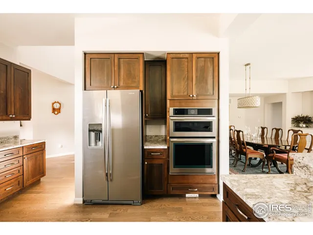 a kitchen with stainless steel appliances kitchen island granite countertop a refrigerator and cabinets