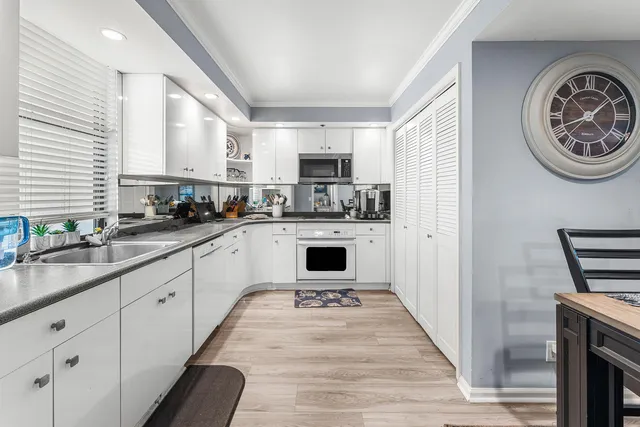 a kitchen with granite countertop white cabinets and white appliances