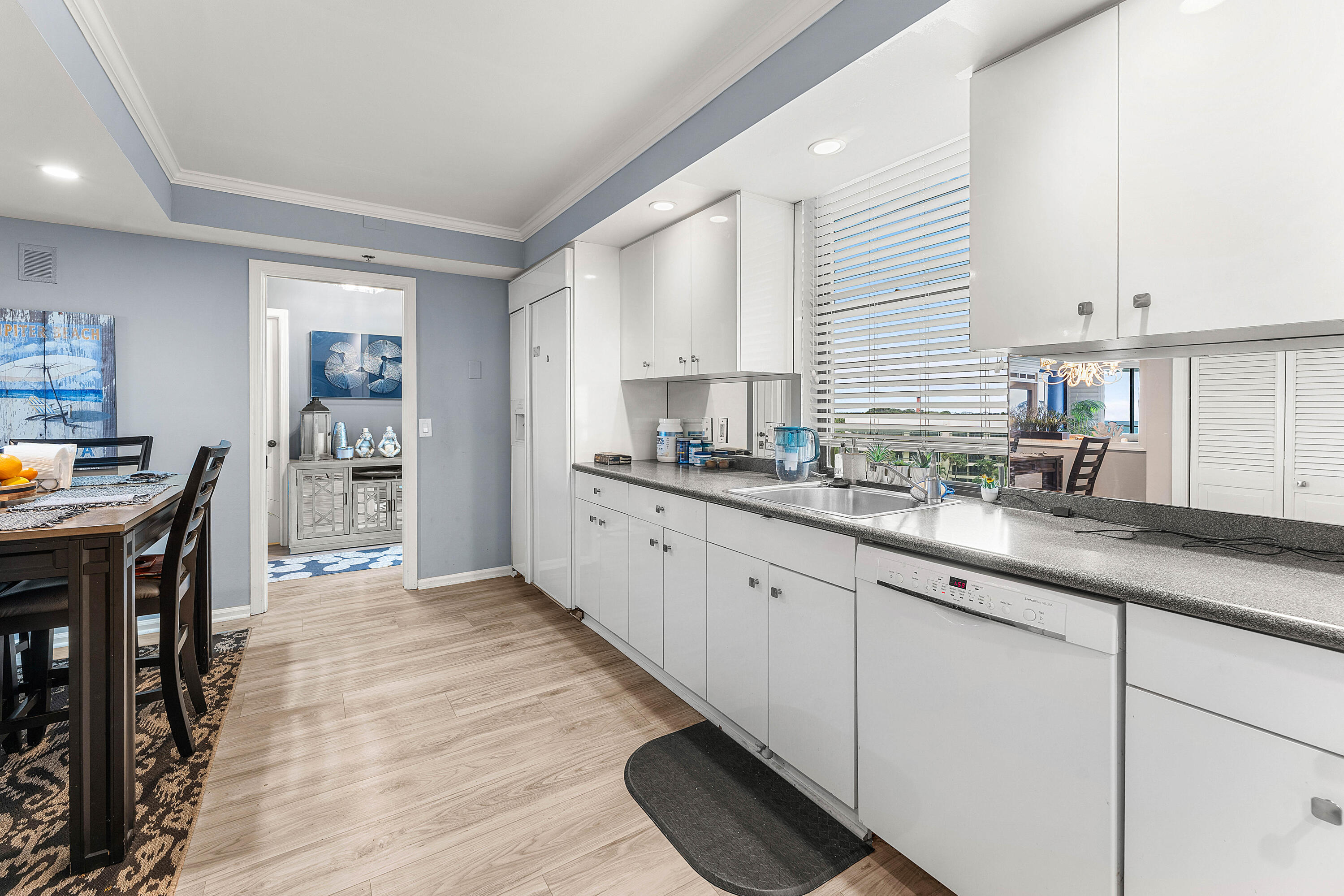 100 South Beach Road, Unit 602 Tequesta, FL 33469 - Photo 7 of 57 a kitchen with granite countertop a sink cabinets and window