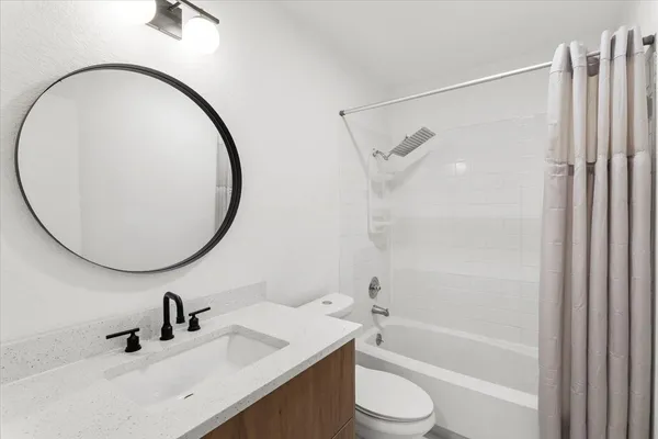a bathroom with a sink a toilet and a mirror