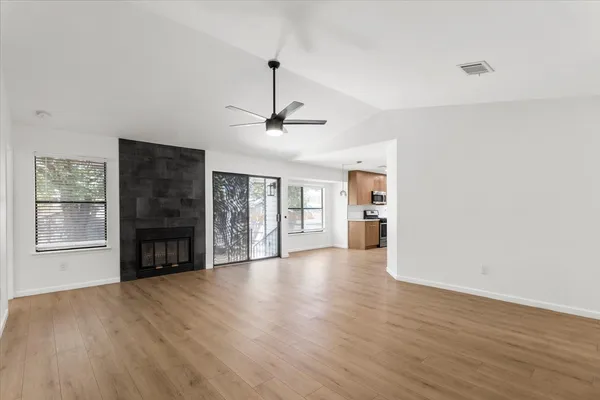 a view of an empty room with a fireplace and a window