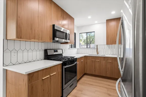 a kitchen with stainless steel appliances granite countertop a stove a sink and a microwave