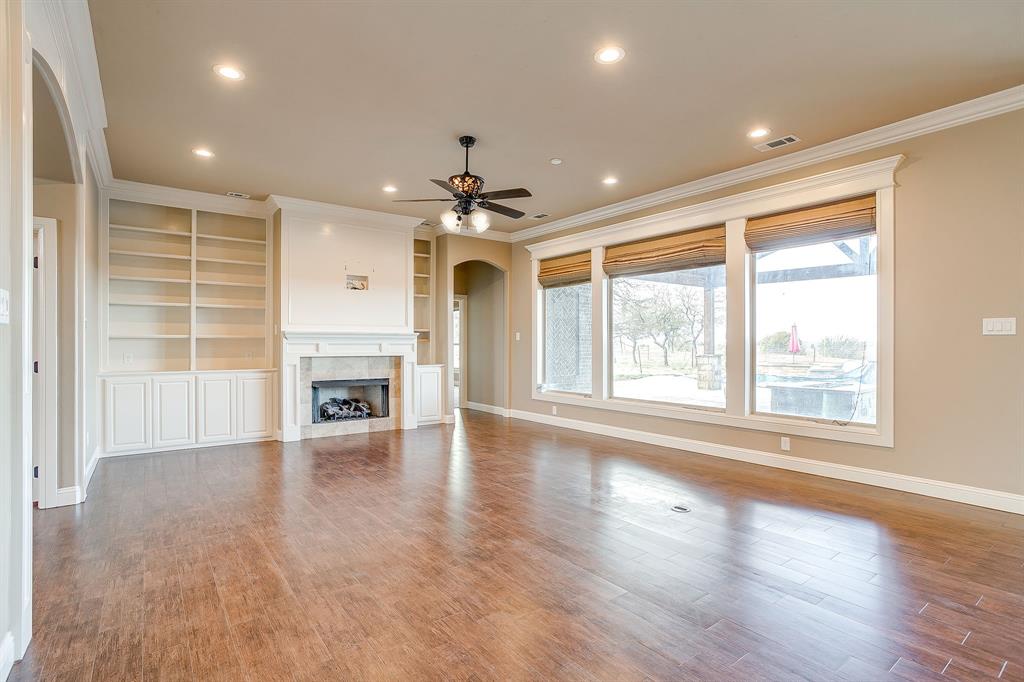 1600 Oak Ridge Estates Weatherford, TX 76085 - Photo 11 of 40 an empty room with wooden floor fireplace and windows