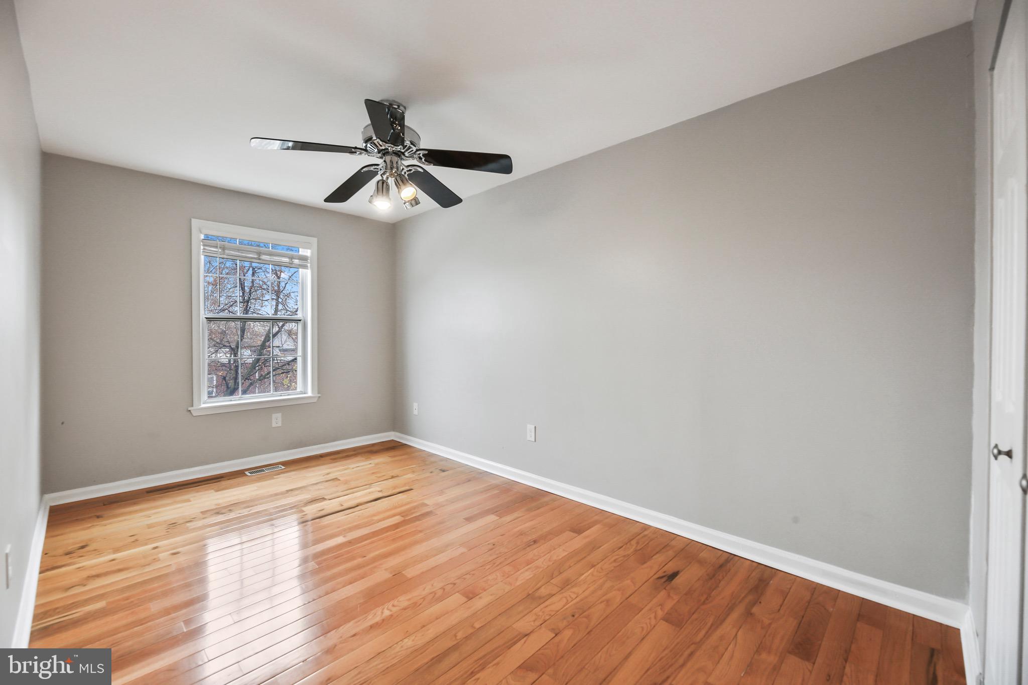 6218 Lindbergh Blvd. Philadelphia, PA 19142 - Photo 8 of 17 an empty room with wooden floor ceiling fan and windows