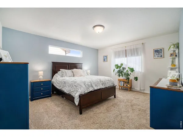 a bedroom with a bed window and a dresser