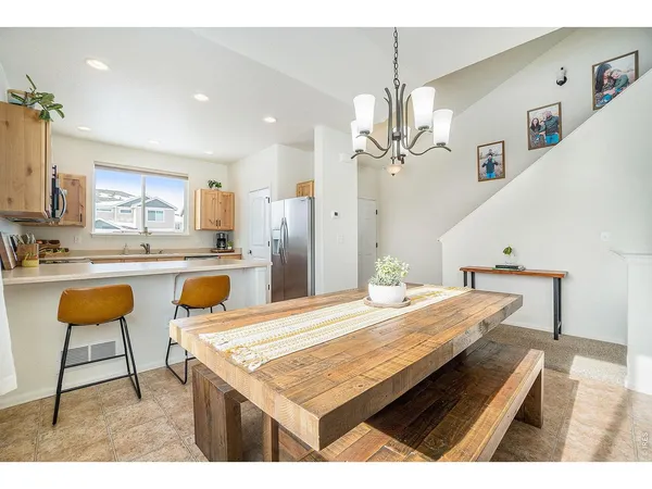 a dining hall with stainless steel appliances kitchen island granite countertop furniture and a kitchen view