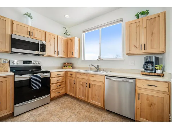 a kitchen with stainless steel appliances granite countertop a stove a sink dishwasher and a microwave oven with cabinets