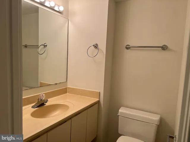 a bathroom with a granite countertop sink toilet and a mirror