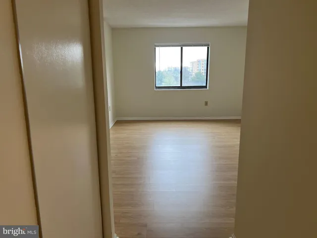 an empty room with windows and closet