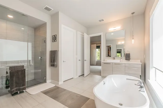 a bathroom with a tub sink shower and mirror