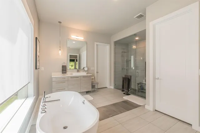 a bathroom with a tub a sink and mirror