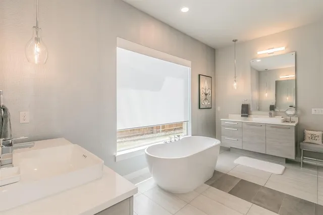 a bathroom with a white tub sink and mirror