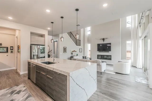 a large kitchen with stainless steel appliances a lot of counter space and a wooden floor