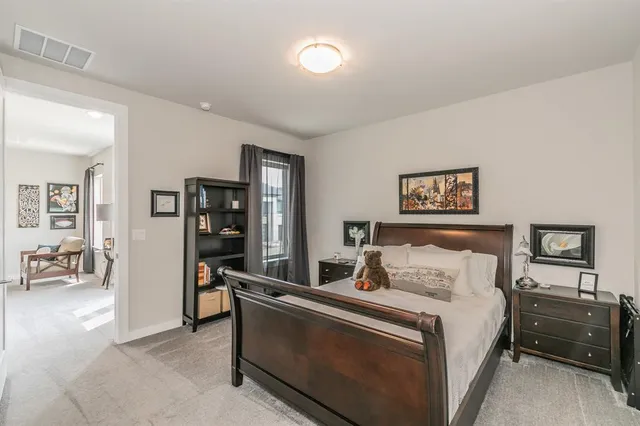 a bedroom with a bed and a view of living room