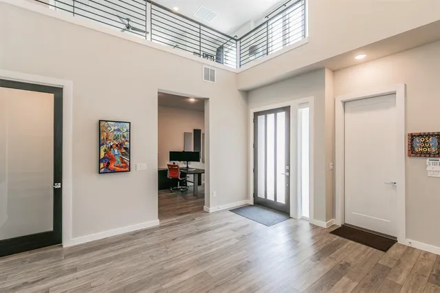 a view of a hallway with wooden floor and furniture