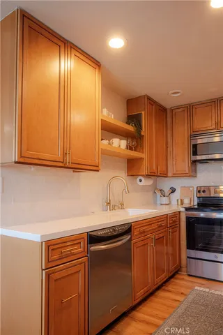 a kitchen with stainless steel appliances granite countertop a sink stove and cabinets