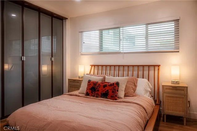 a bed sitting in a bedroom next to a window and a chandelier