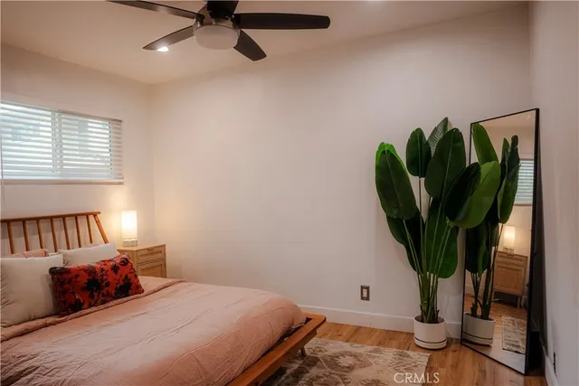 a bedroom with a bed a couch and potted plant