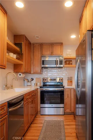 a kitchen with stainless steel appliances granite countertop a sink stove and refrigerator