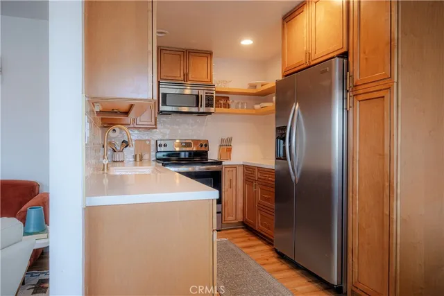 a kitchen with stainless steel appliances a refrigerator sink and microwave