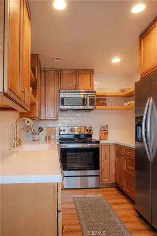 a kitchen with stainless steel appliances granite countertop a sink stove and refrigerator