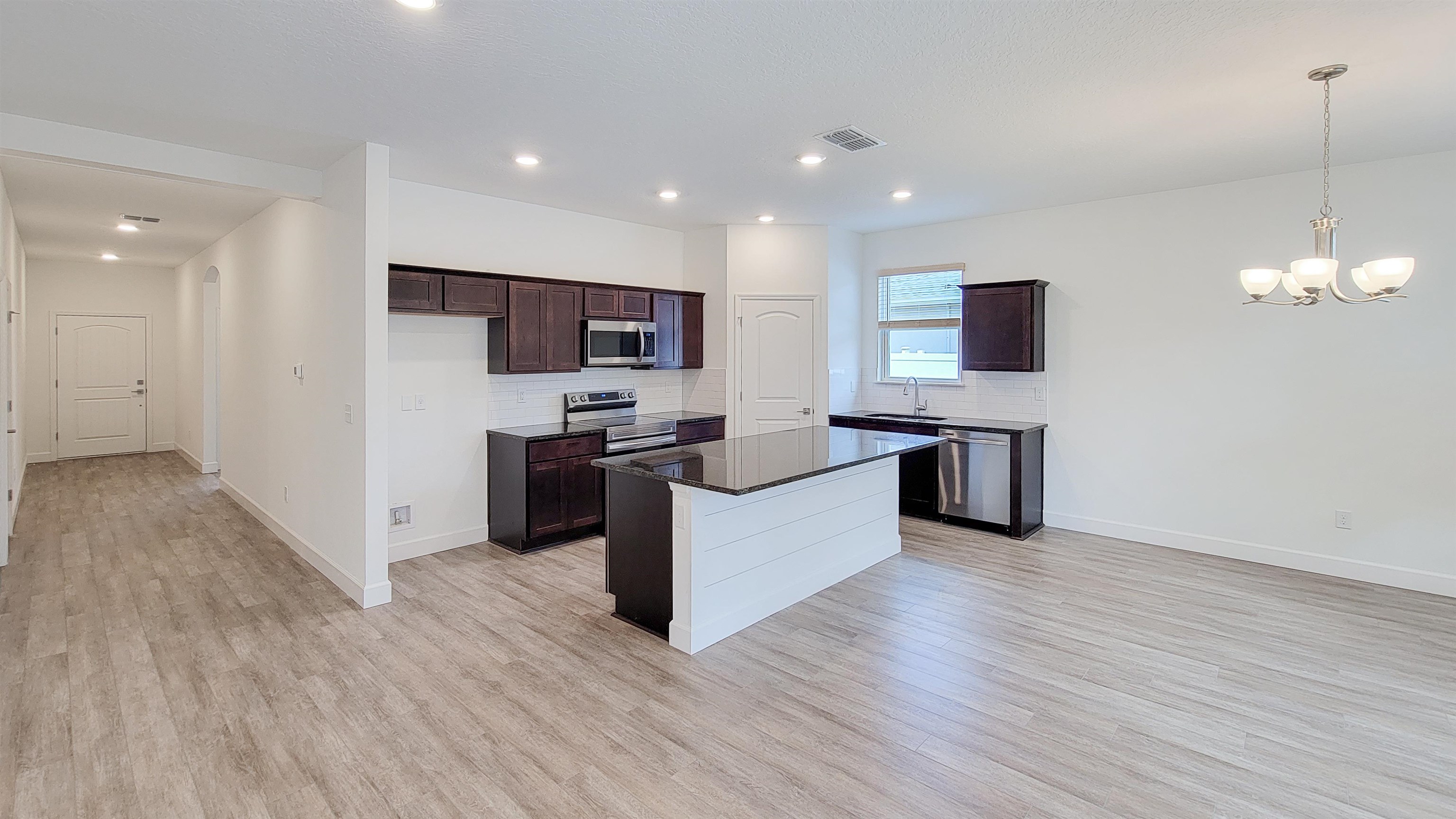62 Roxboro Drive Palm Coast, FL 32164 - Photo 11 of 35 a large kitchen with stainless steel appliances granite countertop a large counter top and a wooden floor