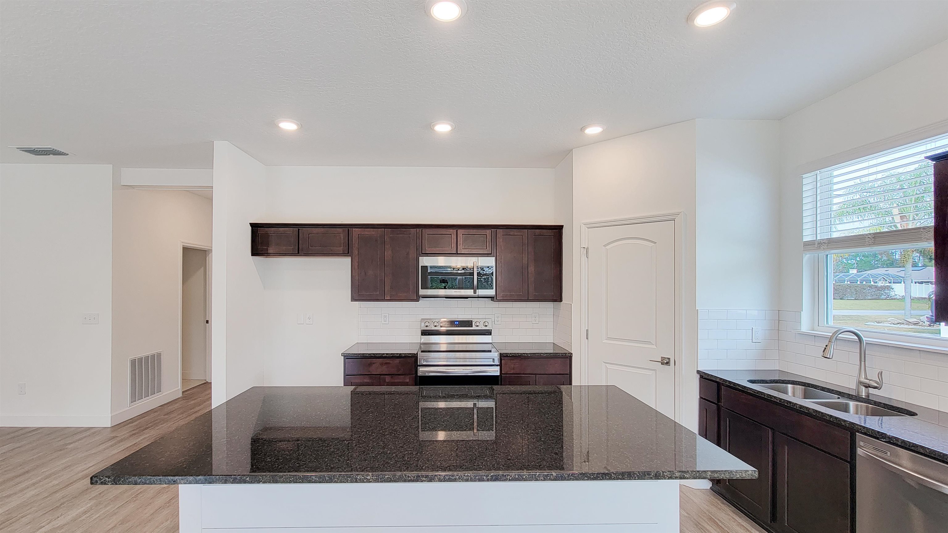 62 Roxboro Drive Palm Coast, FL 32164 - Photo 12 of 35 a kitchen with stainless steel appliances granite countertop a sink stove and refrigerator
