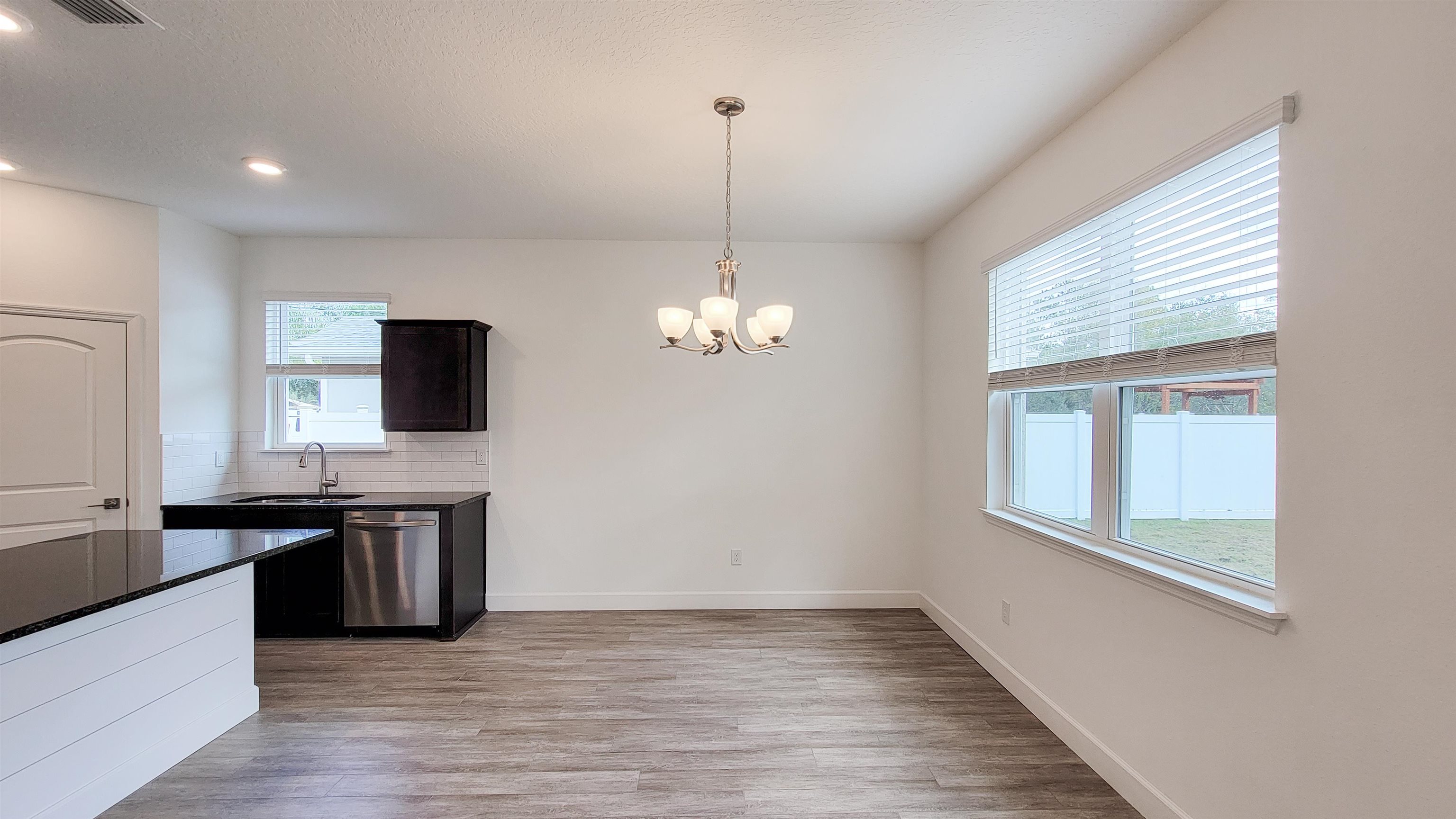 62 Roxboro Drive Palm Coast, FL 32164 - Photo 16 of 35 a kitchen with stainless steel appliances granite countertop a sink a stove and a wooden floors