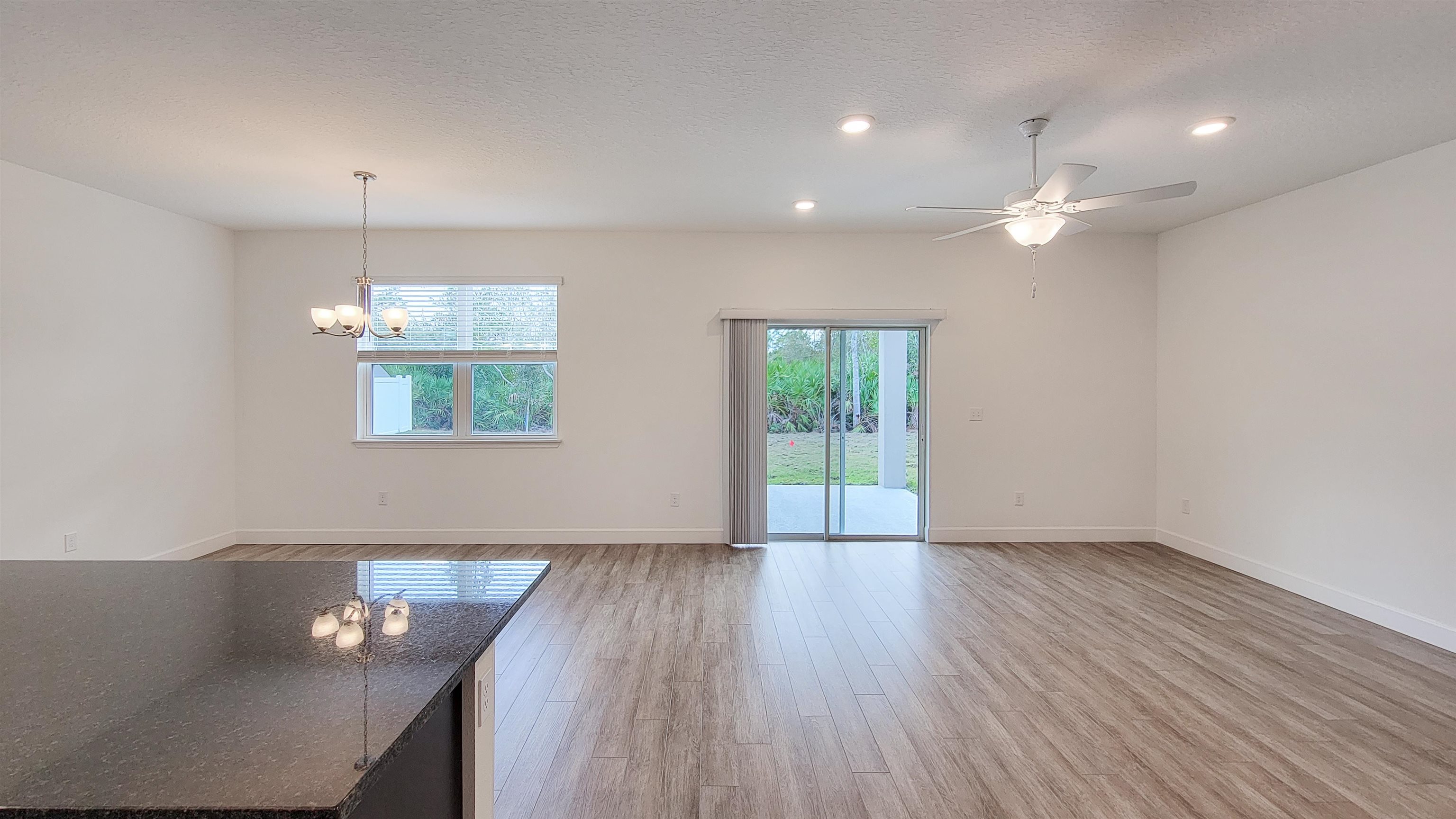 62 Roxboro Drive Palm Coast, FL 32164 - Photo 17 of 35 wooden floor in an empty room with a window
